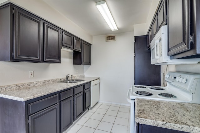 kitchen featuring white appliances, a sink, light countertops, and light tile patterned floors