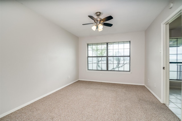 empty room featuring carpet, ceiling fan, baseboards, and a smoke detector