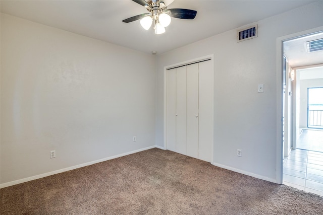 unfurnished bedroom featuring carpet flooring, baseboards, a closet, and ceiling fan
