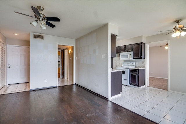 unfurnished living room with a ceiling fan, light wood-type flooring, and baseboards