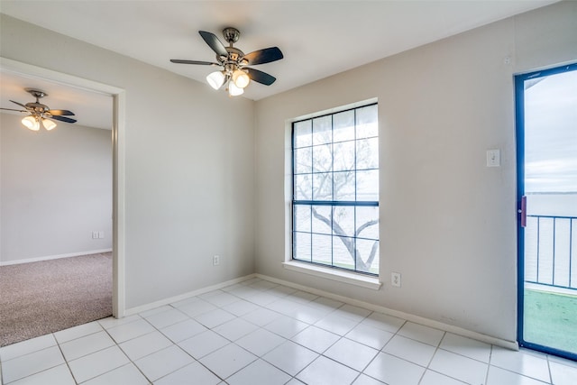 unfurnished room with ceiling fan, baseboards, and light tile patterned flooring