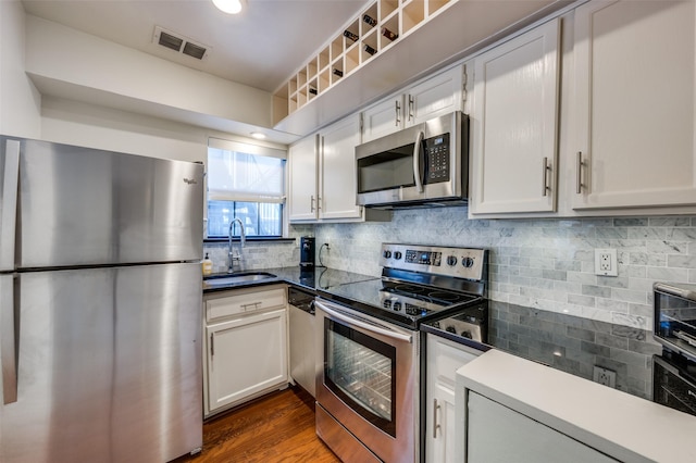 kitchen featuring white cabinetry, appliances with stainless steel finishes, sink, and backsplash