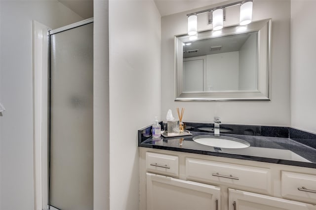 bathroom featuring walk in shower and vanity