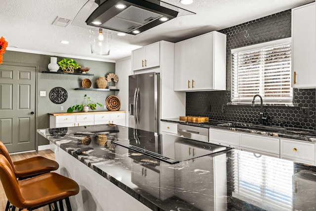 kitchen with sink, a breakfast bar area, stainless steel appliances, extractor fan, and white cabinets