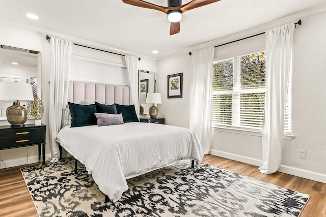 bedroom with wood-type flooring, ornamental molding, and ceiling fan