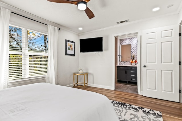 bedroom with connected bathroom, hardwood / wood-style floors, crown molding, and ceiling fan