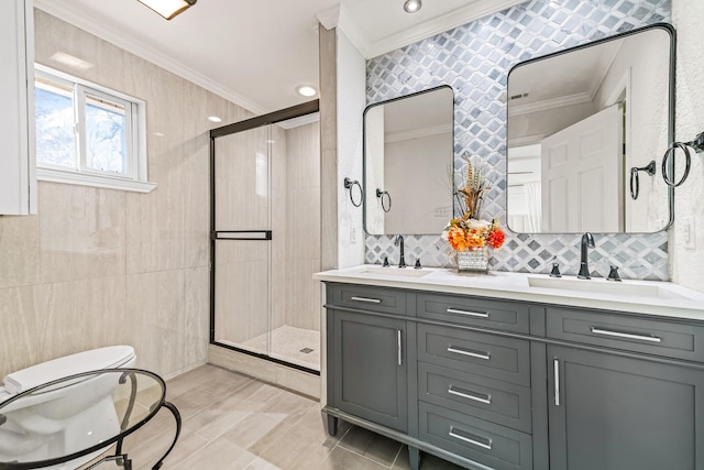 bathroom with vanity, a shower with shower door, and ornamental molding