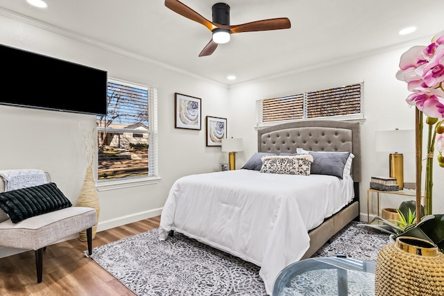 bedroom with crown molding, hardwood / wood-style flooring, and ceiling fan