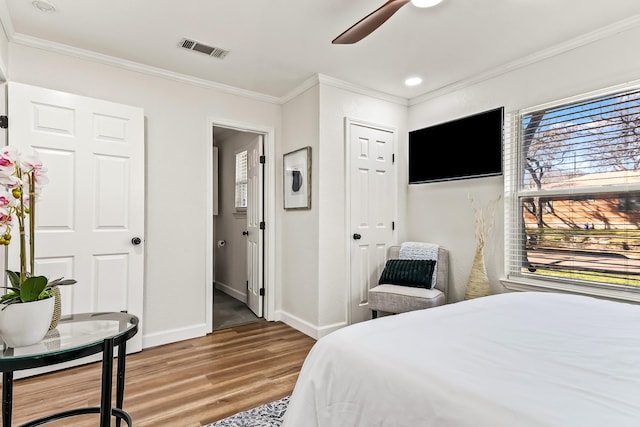 bedroom featuring hardwood / wood-style floors, ornamental molding, and ceiling fan