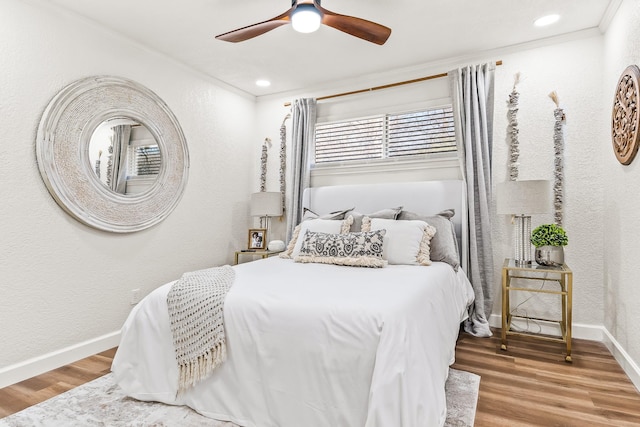 bedroom featuring wood-type flooring, ornamental molding, and ceiling fan