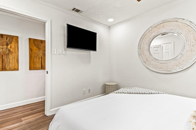 bedroom with crown molding, wood-type flooring, and ceiling fan