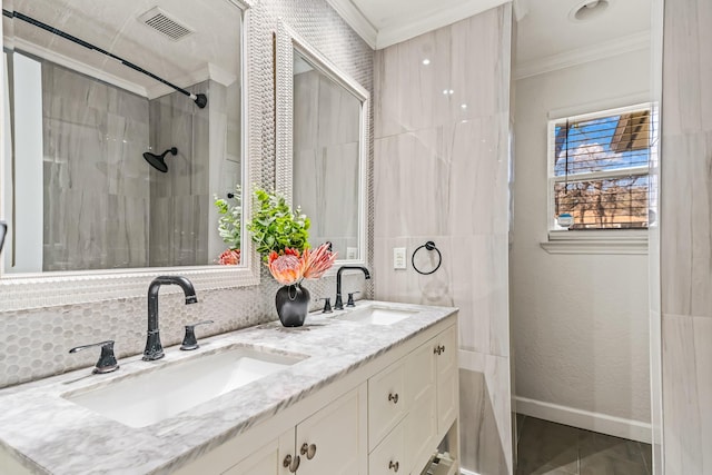 bathroom featuring crown molding, tiled shower, vanity, and decorative backsplash