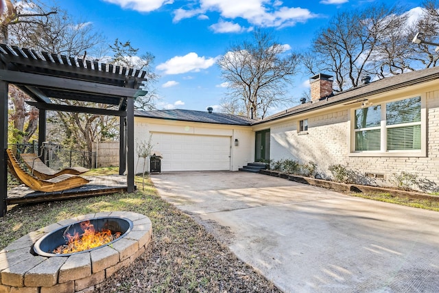 exterior space with a garage and an outdoor fire pit