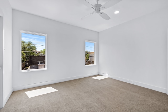 carpeted spare room with ceiling fan