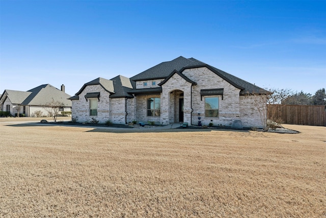 french country inspired facade featuring a front lawn