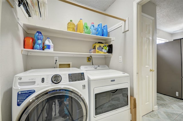 washroom featuring separate washer and dryer and a textured ceiling