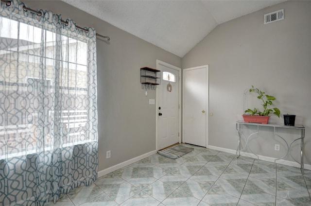 entrance foyer with light tile patterned flooring and lofted ceiling