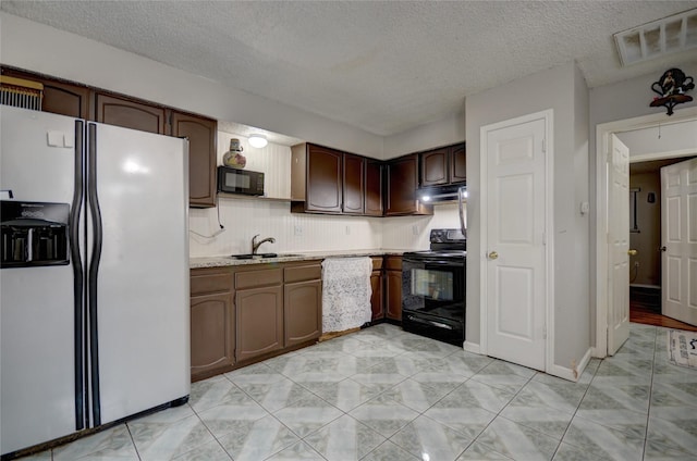 kitchen with sink, decorative backsplash, dark brown cabinetry, and black appliances