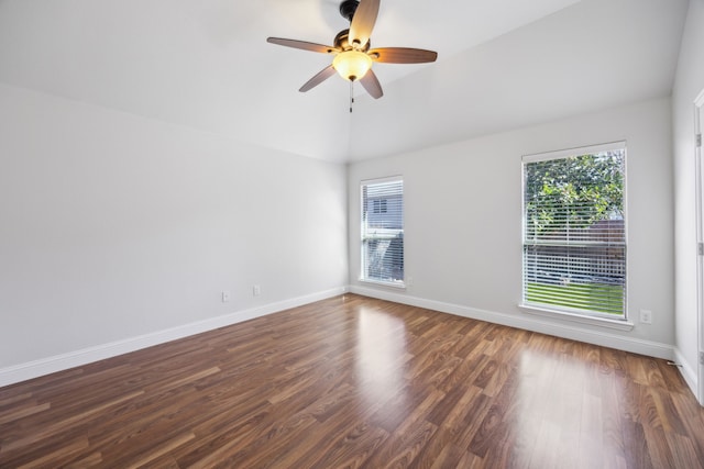 empty room with lofted ceiling, dark hardwood / wood-style floors, and ceiling fan