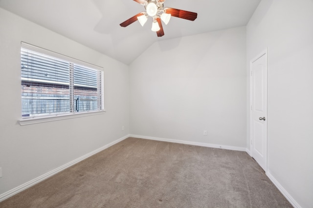 empty room featuring lofted ceiling, light carpet, and ceiling fan