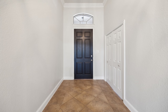 tiled entryway featuring crown molding