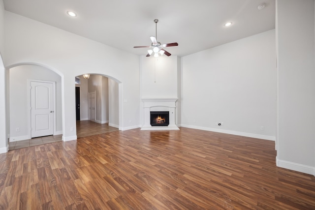 unfurnished living room with dark wood-type flooring and ceiling fan