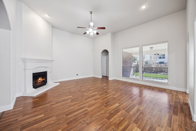 unfurnished living room featuring ceiling fan and dark hardwood / wood-style flooring