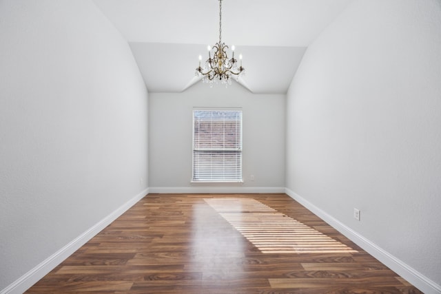 spare room with lofted ceiling, dark hardwood / wood-style floors, and an inviting chandelier