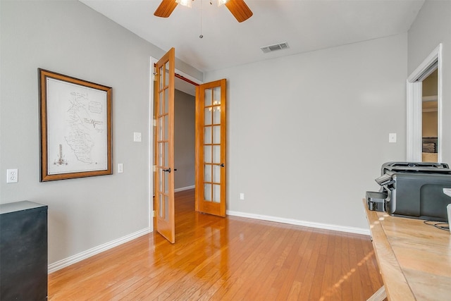 living room featuring wood-type flooring, french doors, and ceiling fan