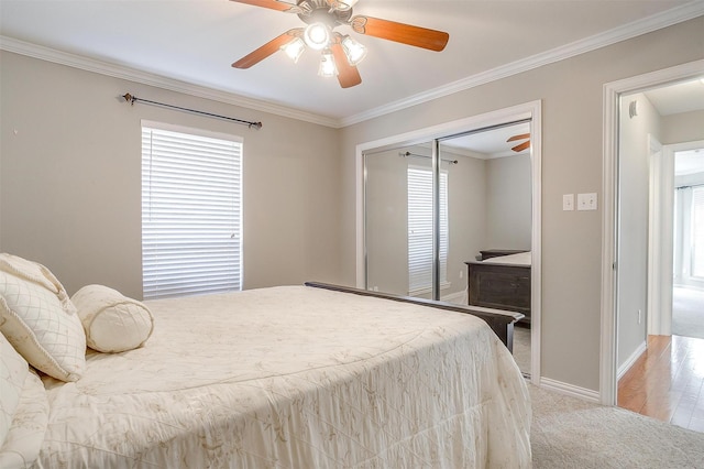 bedroom with ornamental molding, light colored carpet, a closet, and ceiling fan