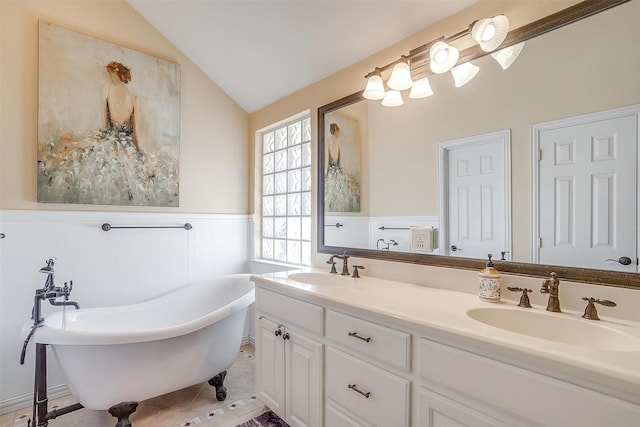 bathroom with lofted ceiling, vanity, a washtub, and tile patterned flooring