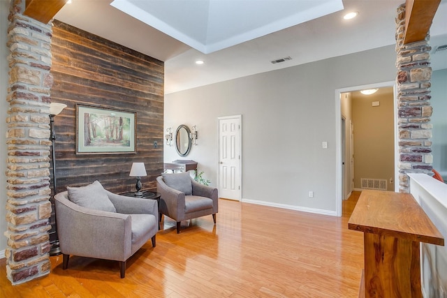 sitting room featuring light hardwood / wood-style flooring and wood walls