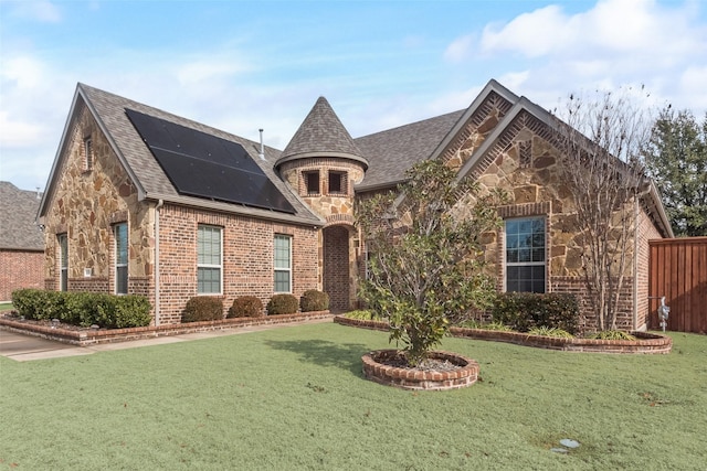 view of front of house featuring a front yard and solar panels