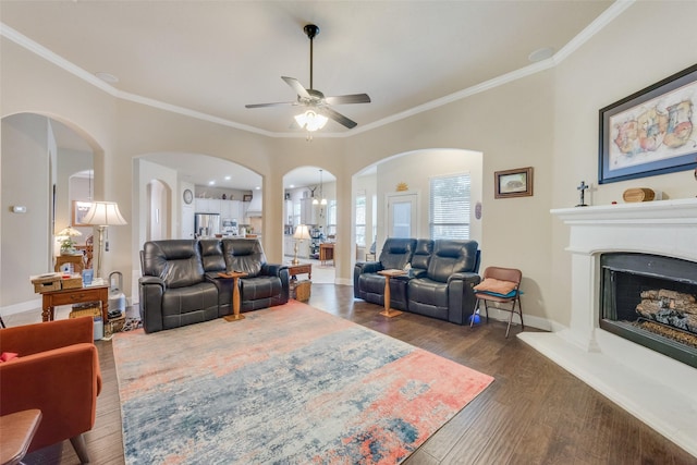 living room with crown molding, dark hardwood / wood-style floors, and ceiling fan