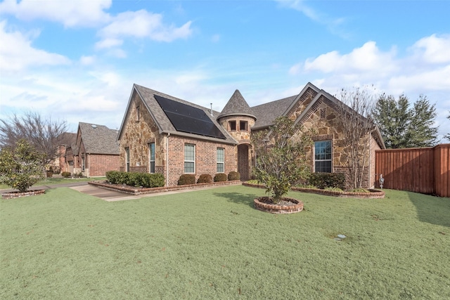 view of front of house with a front lawn and solar panels