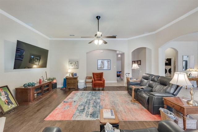 living room with dark hardwood / wood-style flooring, ornamental molding, ceiling fan, and washer and clothes dryer