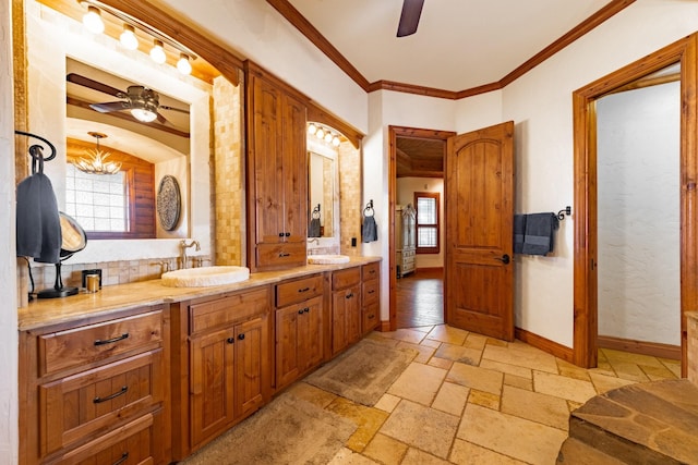 bathroom with vanity, ceiling fan with notable chandelier, backsplash, and crown molding