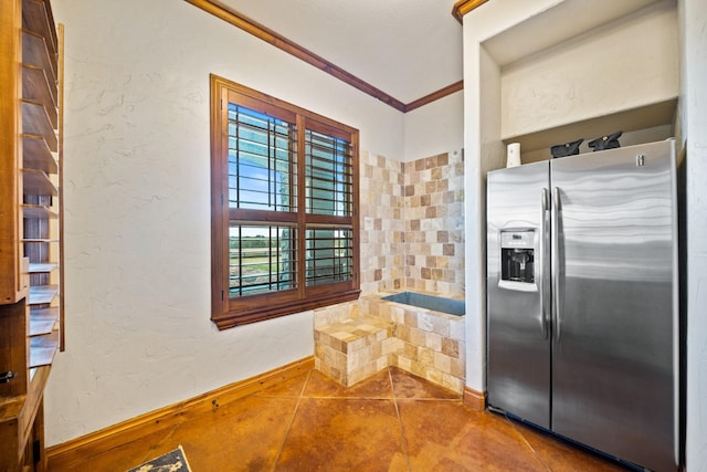 kitchen featuring tile patterned floors, ornamental molding, and stainless steel fridge