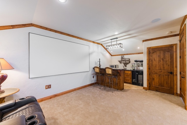 carpeted home theater featuring vaulted ceiling, beverage cooler, and indoor bar