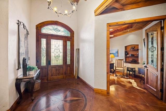 entryway featuring wood ceiling, beamed ceiling, dark tile patterned floors, and a notable chandelier