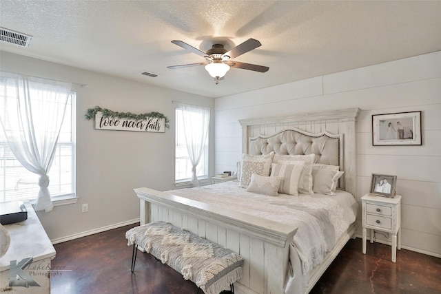 bedroom with multiple windows, ceiling fan, and a textured ceiling