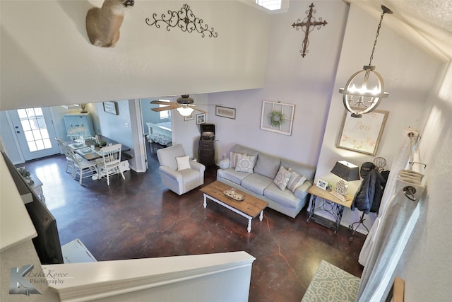 living room with ceiling fan with notable chandelier