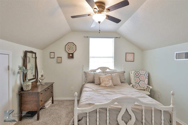 bedroom featuring ceiling fan, lofted ceiling, light colored carpet, and a textured ceiling