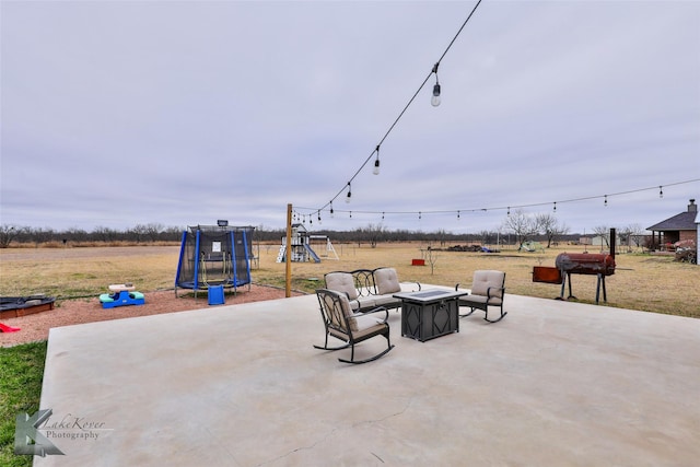 view of patio with a grill, a playground, and a trampoline