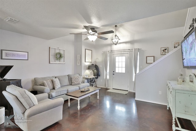 living room with lofted ceiling, ceiling fan, and a textured ceiling