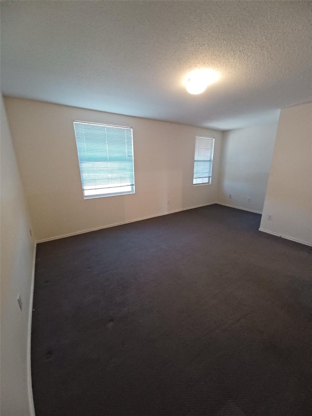 carpeted spare room with a textured ceiling