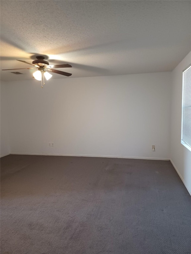 carpeted empty room with ceiling fan and a textured ceiling