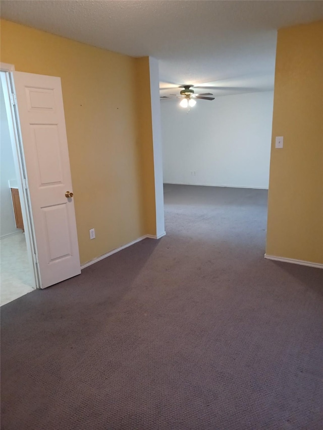 carpeted empty room with ceiling fan and a textured ceiling