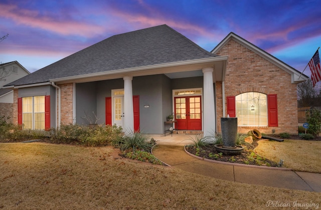 view of front of home with a lawn and french doors