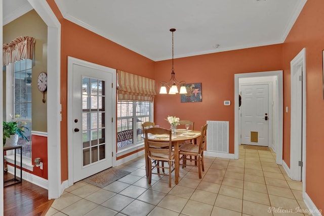 tiled dining room featuring crown molding and an inviting chandelier